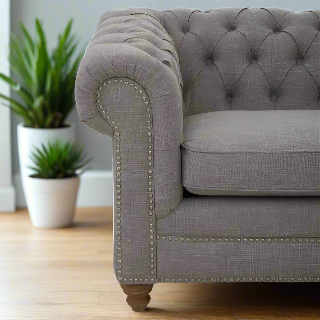 Introducing our classic chesterfield two-seat sofa, featuring a button-tufted back that exudes luxury with a touch of warmth. Timeless and elegant, it boasts gently scrolled arms that complement its smooth lines. The nail head trims add a finishing touch to the design, making this sofa a sophisticated addition to any living space.