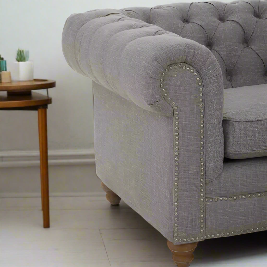 Introducing our classic chesterfield two-seat sofa, featuring a button-tufted back that exudes luxury with a touch of warmth. Timeless and elegant, it boasts gently scrolled arms that complement its smooth lines. The nail head trims add a finishing touch to the design, making this sofa a sophisticated addition to any living space.