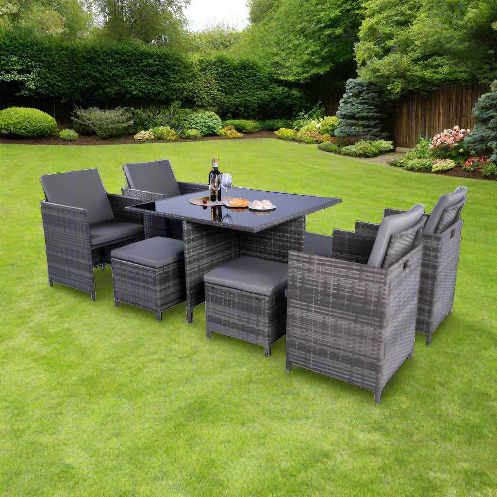 Milano 9-piece cube dining set with black rattan, tempered black glass table, four chairs, and four stools with cushions, designed for outdoor dining and easy storage when not in use.
