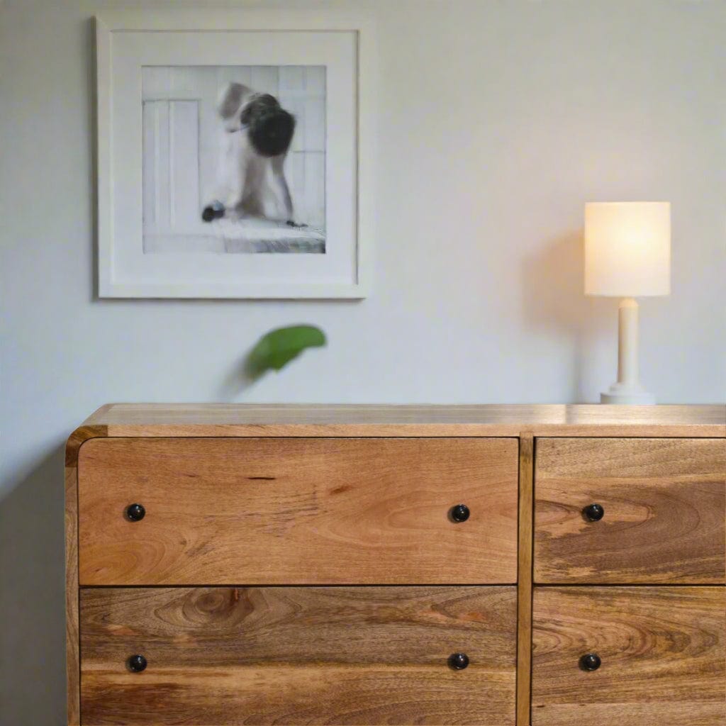 "Large Chest of Drawers made from 100% solid mango wood with oak-like finish, featuring Nordic-style legs, shiny accent knobs, and a modern curved design for contemporary home interiors."