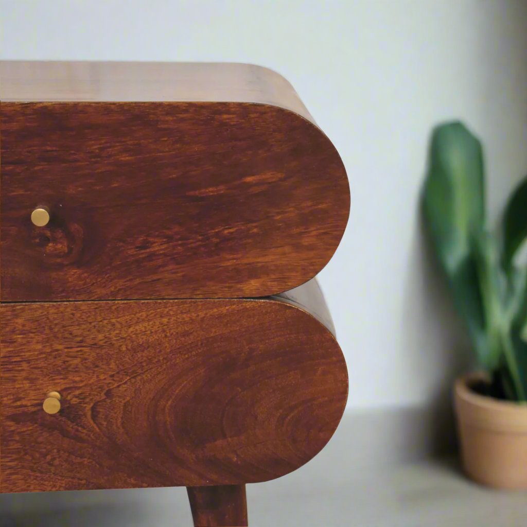 Quirky Capsule-Style Bedside Table with round drawer designs, crafted from 100% solid mango wood in a warm chestnut finish. Supported by Nordic-style legs and featuring shiny brass knobs for a modern, stylish look.