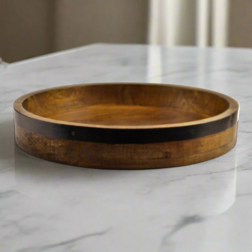 A Dark Wood Circular Serving Tray featuring a sleek, round design with a rich, dark wood finish. This elegant serving tray is perfect for serving drinks, appetizers, or organizing small items. The smooth, durable surface adds sophistication to any dining or living space, while the round shape enhances its stylish appeal. Ideal for both functional and decorative use, this dark wood tray complements modern, rustic, or traditional interiors, offering both practicality and charm to your home decor.