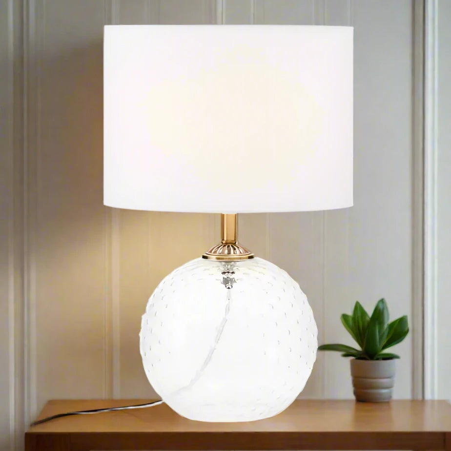 Modern glass circular white table lamp with a sleek design, featuring a round base and a minimalist shade, perfect for adding a touch of elegance and ambient lighting to any room