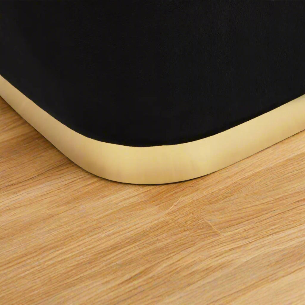 Black velvet stool with square design and matte gold finish base, offering a contemporary luxe style.