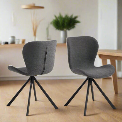 Set of two dining chairs with black steel swivel base, cream bouclé fabric upholstery, and zigzag stitching, featuring a modern Danish design.