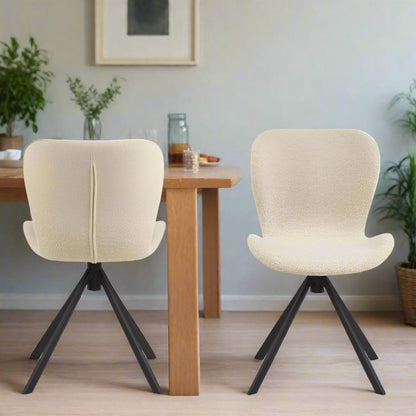 Set of two dining chairs with black steel swivel base, cream bouclé fabric upholstery, and zigzag stitching, featuring a modern Danish design.