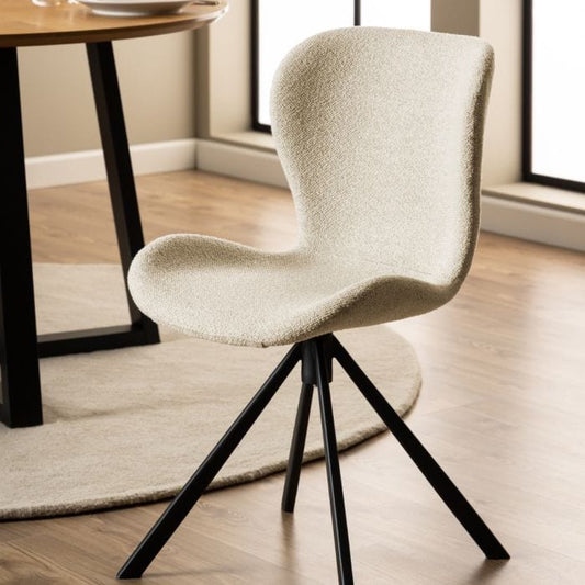 Set of two dining chairs with black steel swivel base, cream bouclé fabric upholstery, and zigzag stitching, featuring a modern Danish design.