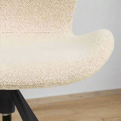 Set of two dining chairs with black steel swivel base, cream bouclé fabric upholstery, and zigzag stitching, featuring a modern Danish design.
