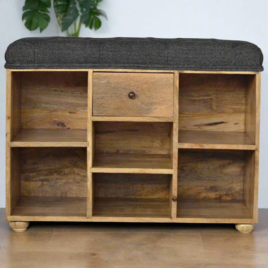 Small shoe storage bench with oak-ish finish, black tweed upholstered seat, 1 drawer with shiny knob, 6 open shelves, and 4 bun feet.