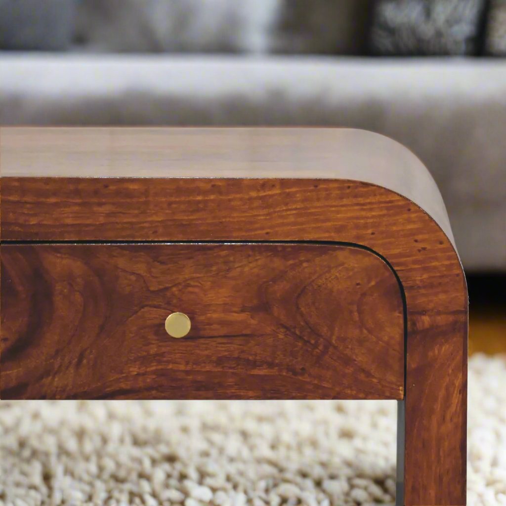 
A Chestnut Rounded Edge Coffee Table featuring a smooth, rounded design and a rich chestnut wood finish. This elegant coffee table offers a spacious surface for drinks, books, and decor, adding both style and functionality to your living room. The rounded edges provide a soft, modern aesthetic, making it a perfect fit for contemporary or traditional interiors. Crafted from high-quality wood, this coffee table enhances your home decor with its timeless appeal and versatile design.