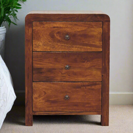 Chestnut Curved Edge Bedside Table with 3 spacious drawers, shiny brass knobs, and rounded corner edges. Crafted from 100% solid mango wood with a chestnut finish, offering both style and functionality for the bedroom.