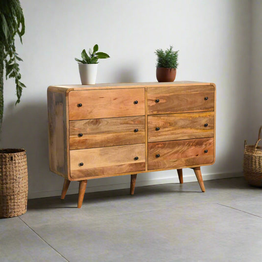 "Large Chest of Drawers made from 100% solid mango wood with oak-like finish, featuring Nordic-style legs, shiny accent knobs, and a modern curved design for contemporary home interiors."