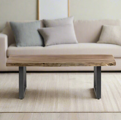 Coffee table with live edge solid acacia wood top, eco-friendly, supported by sturdy sled-shaped metal legs for a natural, rustic look.
