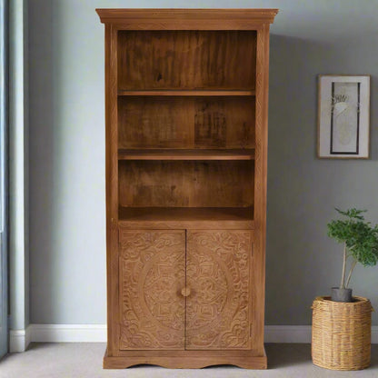 Handcrafted large bookcase made from eco-sourced mango wood, featuring hand-carved detailing, open shelving, and a two-door cupboard with a light whitewash finish