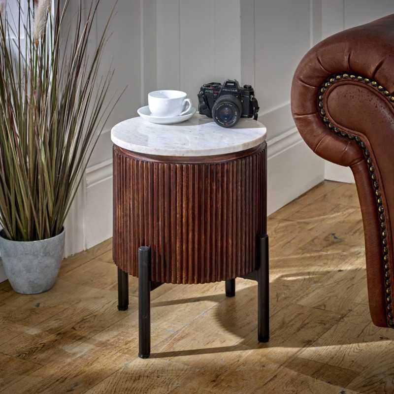 "Handcrafted bedside table with a natural marble top, fluted mango wood surround, and metal legs, perfect for holding drinks, remotes, and mobile phones, with easy maintenance."