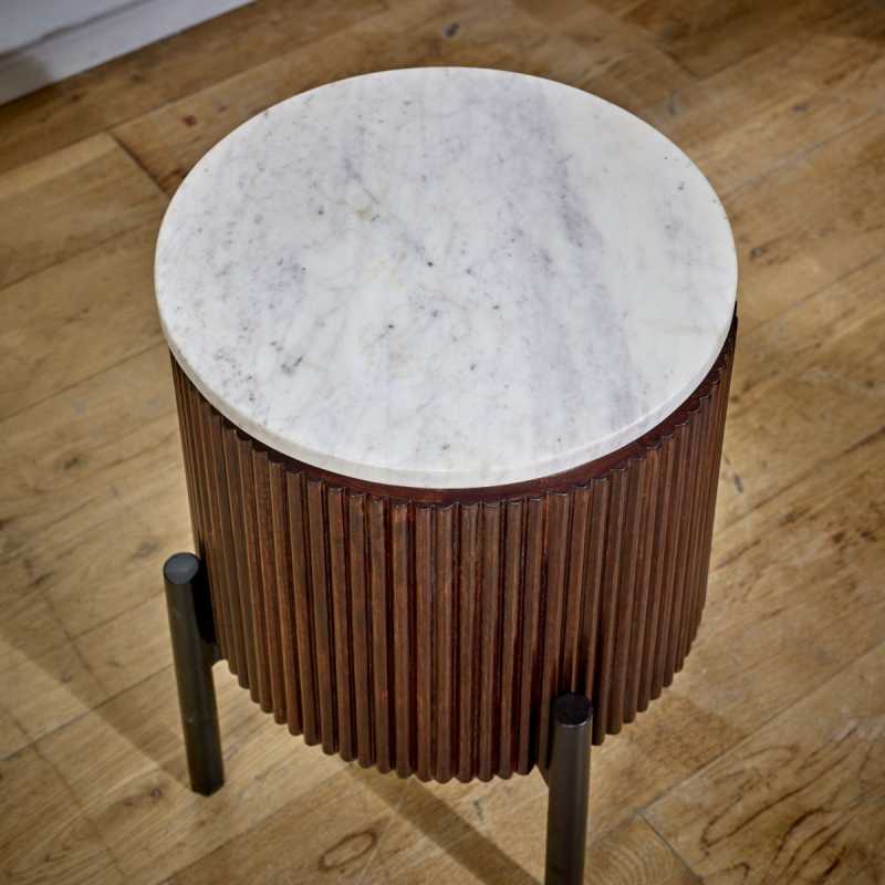 "Handcrafted bedside table with a natural marble top, fluted mango wood surround, and metal legs, perfect for holding drinks, remotes, and mobile phones, with easy maintenance."