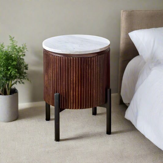 "Handcrafted bedside table with a natural marble top, fluted mango wood surround, and metal legs, perfect for holding drinks, remotes, and mobile phones, with easy maintenance."